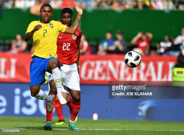 Brazil's forward Douglas Costa and Austria's defender Kevin Danso vie for the ball during the international friendly footbal match Austria vs Brazil...