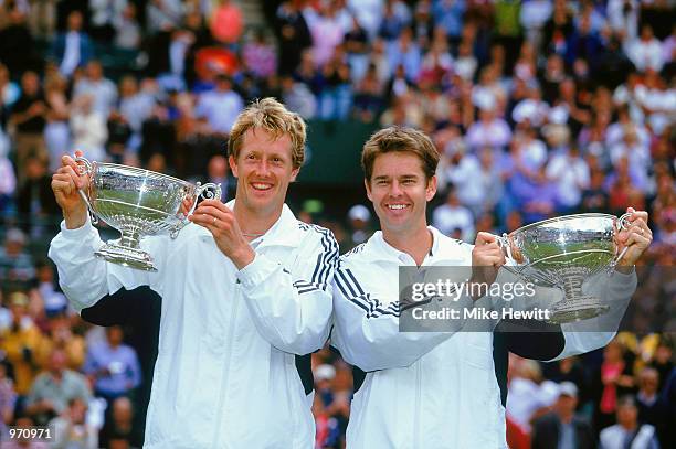 Jonas Bjorkman of Sweden and Todd Woodbridge of Australia lift their trophies after victory over Mark Knowles and Daniel Nestor in the Men's Doubles...