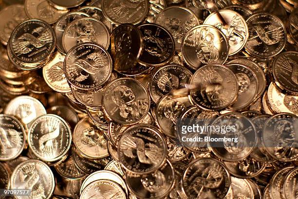 Sacagawea dollar coins sit in a bin after being struck at the United States Mint in Philadelphia, Pennsylvania, U.S., on Thursday, Feb. 25, 2010. The...