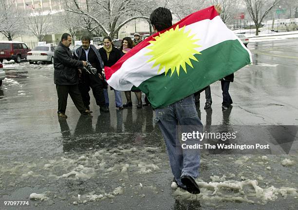 Nabaz Alan of Centerville, VA, and other Iraqi Kurds dance with the Kurdish flag across the street from the Iraq polling place in Maryland. Iraqi...