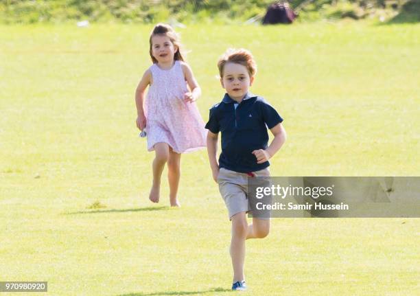 Prince George of Cambridge and Princess Charlotte of Cambridge run together during the Maserati Royal Charity Polo Trophy at Beaufort Park on June...