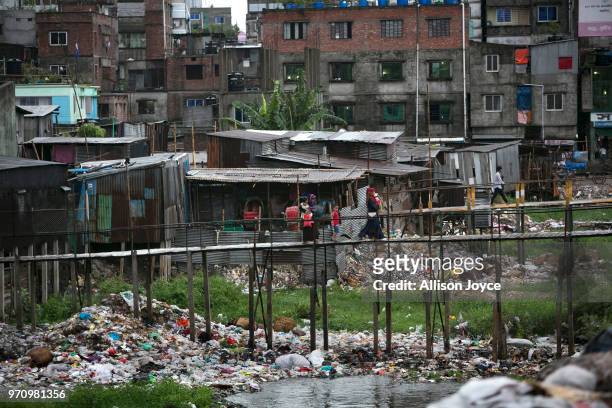 People walk over a polluted canal that leads to the Buriganga river June 10, 2018 in Dhaka, Bangladesh. Bangladesh has been reportedly ranked 10th...