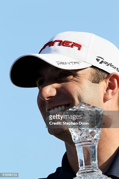 Dustin Johnson holds the trophy on the 18th green after the final round of the AT&T Pebble Beach National Pro-Am at Pebble Beach Golf Links on...