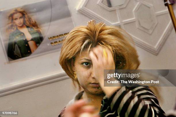 Halla Muhammed Maarouf fixers her hair like Britney Spears in a beauty salon next to her Baghdad home. Halla has been supporting her children,...