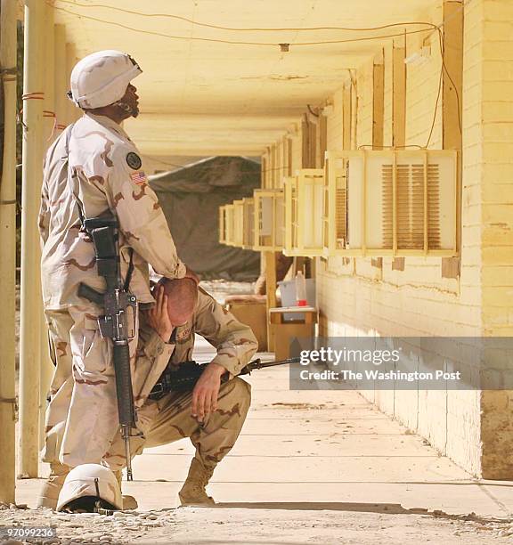 At one of the 1st Infantry Division bases, FOB Gabe, Spec. Jarrod Matthews is comforted by Staff Sgt. Jason Bacon after a memorial service for PFC...