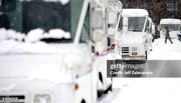 Letter carrier walks through snowdrifts to his mail truck February 26, 2010 in Maplewood, New Jersey. Over a foot of powdery, drifting snow fell...