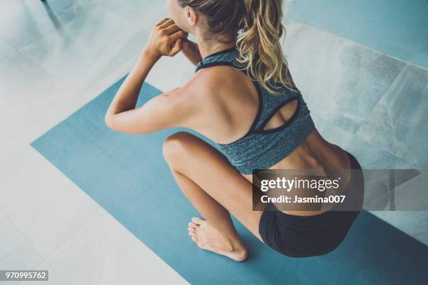 deportiva mujer haciendo ejercicio en un gimnasio - crouching fotografías e imágenes de stock