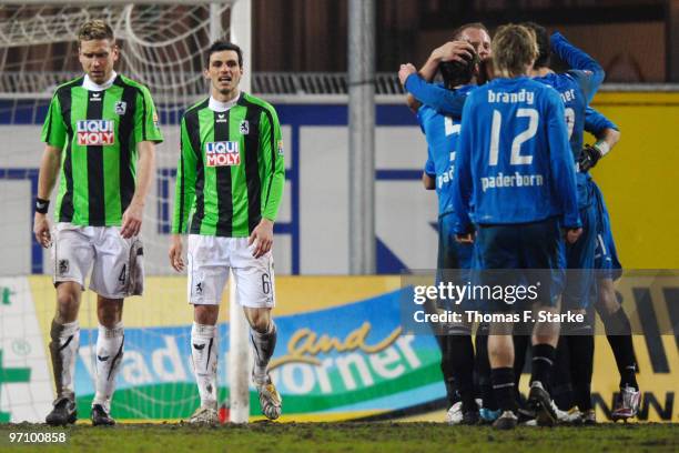 Torben Hoffmann and Mathieu Beda of Munich look dejected while players of Paderborn celebrate their second goal during the Second Bundesliga match...