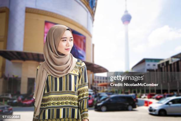 female muslim young adult walking downtown kuala lumpur - menara kuala lumpur tower stock pictures, royalty-free photos & images