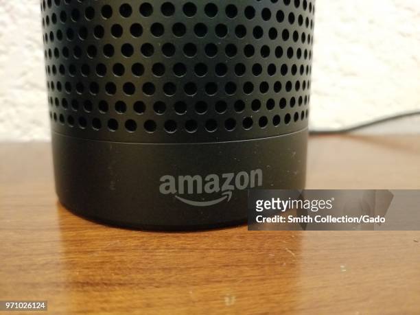 Close-up of the base of an Amazon Echo smart speaker using the Alexa service, with Amazon logo visible, on a light wooden surface, San Ramon,...