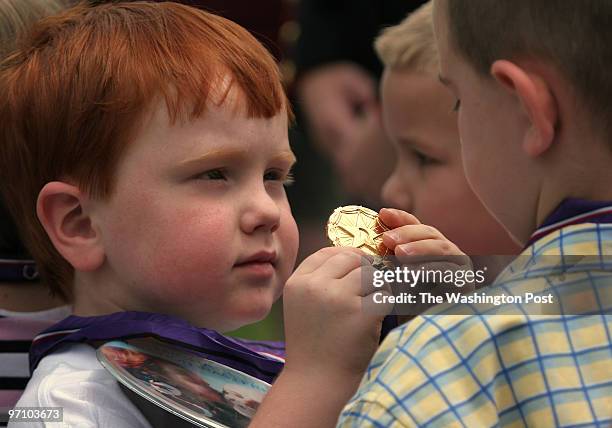 Washington, D.C., William Deem left, shows off his medal to friends during the Gold Medal of Remembrance Presentation Recognizing Children of our...
