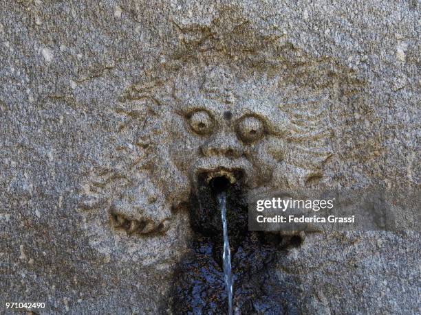 ancient fountain in trarego decorated with singular protome - cannobio fotografías e imágenes de stock