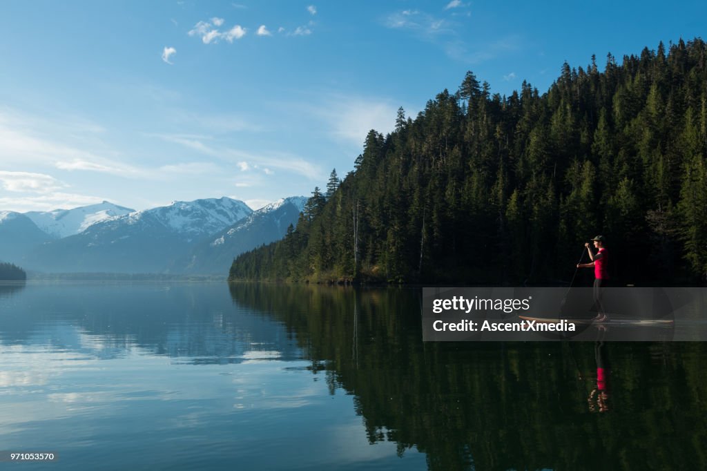 Vrouw stand-up paddle instappen op een ongerepte bergmeer