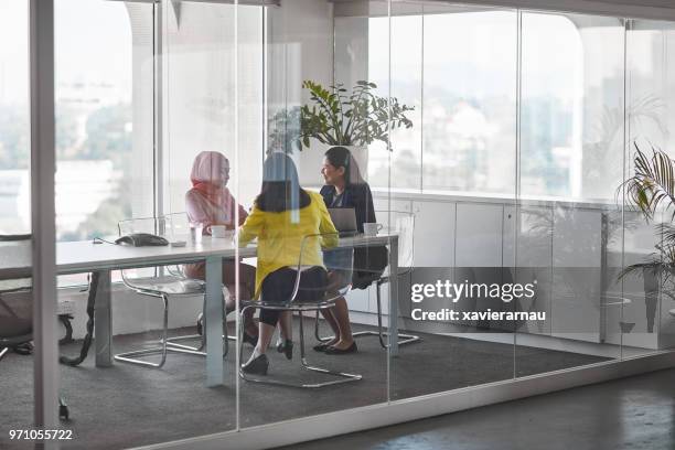 businesswomen discussing in meeting at board room - glass meeting room stock pictures, royalty-free photos & images
