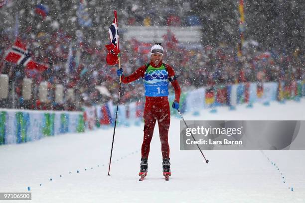 Ole Einar Bjoerndalen of Norway crosses the finish line to win the gold medal in the men's 4 x 7.5 km biathlon relay on day 15 of the 2010 Vancouver...