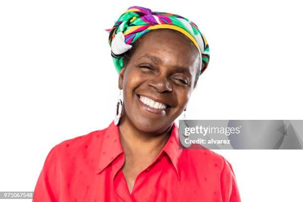 vrolijke senior afrikaanse vrouw in traditionele hoofdtooi - scarf isolated stockfoto's en -beelden