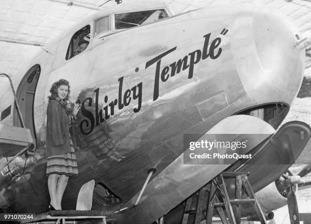 American actress Shirley Temple poses with a US Army C-54 Skymaster transport plane that has been named for her, October 20, 1944.