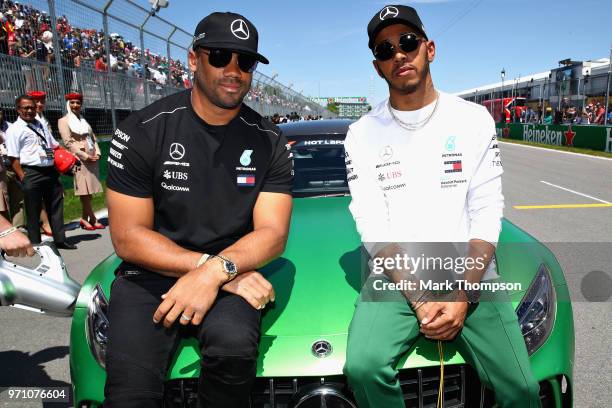 Lewis Hamilton of Great Britain and Mercedes GP poses for a photo with Seattle Seahawks Quarterback Russell Wilson before the Canadian Formula One...