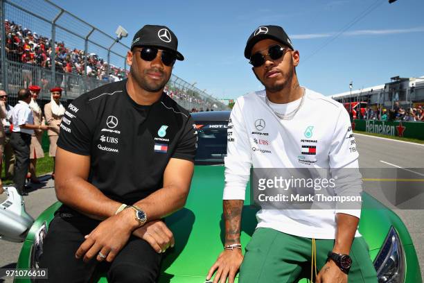 Lewis Hamilton of Great Britain and Mercedes GP poses for a photo with Seattle Seahawks Quarterback Russell Wilson before the Canadian Formula One...