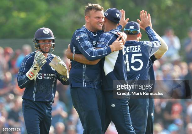 Mark Watt of Scotland celebrates with his team mates after taking the wicket of Sam Billings of England during the One Day International match...