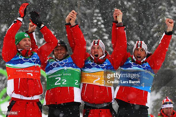 Simon Eder, Daniel Mesotitsch, Dominik Landertinger and Christoph Sumann of Austria celebrate winning the silver medal during the flower ceremony for...