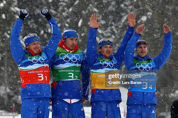 Ivan Tcherezov, Anton Shipulin, Maxim Tchoudov and Evgeny Ustyugov of Russia celebrate winning the bronze medal during the flower ceremony for the...