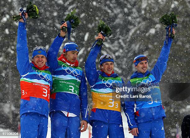 Ivan Tcherezov, Anton Shipulin, Maxim Tchoudov and Evgeny Ustyugov of Russia celebrate winning the bronze medal during the flower ceremony for the...