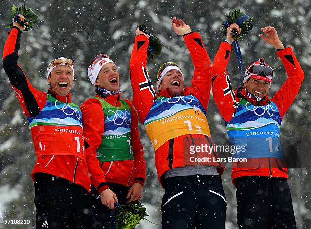 Halvard Hanevold, Tarjei Boe, Emil Hegle Svendsen and Ole Einar Bjoerndalen of Norway celebrate winning the gold medal during the flower ceremony for...