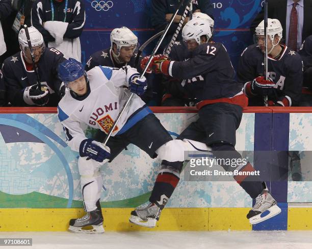 Ryan Malone of the United States checks Toni Lydman of Finland during the ice hockey men's semifinal game between the United States and Finland on...