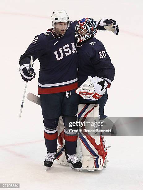 Ryan Whitney of the United States celebrates with goalkeeper Tim Thomas of the United States after they won the ice hockey men's semifinal game...