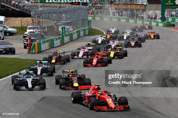 Sebastian Vettel of Germany driving the Scuderia Ferrari SF71H leads the field at the start during the Canadian Formula One Grand Prix at Circuit...