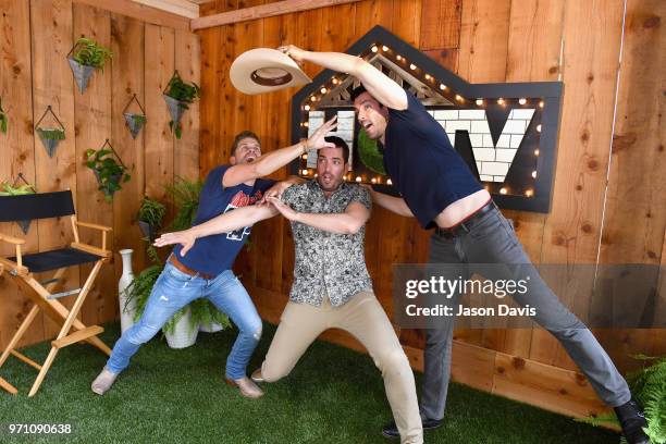 Recording artist Dustin Lynch poses for a photo with the Property Brothers Jonathan Scott and Drew Scott at the HGTV Lodge at CMA Music Fest on June...