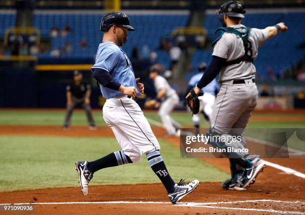 Johnny Field of the Tampa Bay Rays crosses home plate ahead of catcher Mike Zunino of the Seattle Mariners to score off of the throw after Mallex...