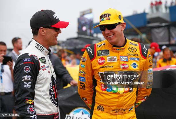 Kevin Harvick, driver of the Jimmy John's Ford, speaks with Kyle Busch, driver of the M&M's Red White & Blue Toyota, during a weather delay prior to...