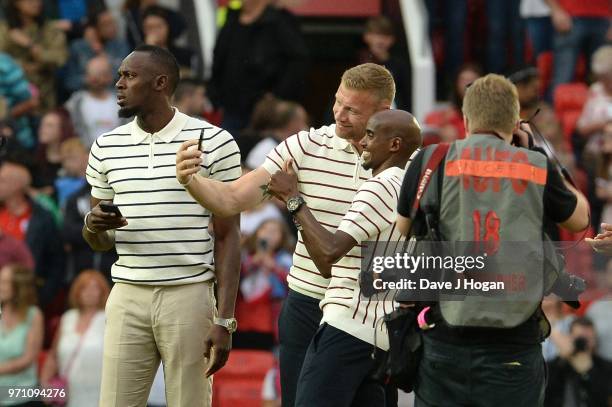 Usain Bolt looks-on as Andrew Flintoff and Mo Farah take a selfie prior to kick off during Soccer Aid for Unicef 2018 at Old Trafford on June 10,...