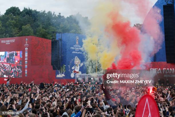 Young man holds smoke flares during the official opening ceremony of the FIFA Fan Fest in Moscow, on June 10 ahead of the Russia 2018 World Cup.