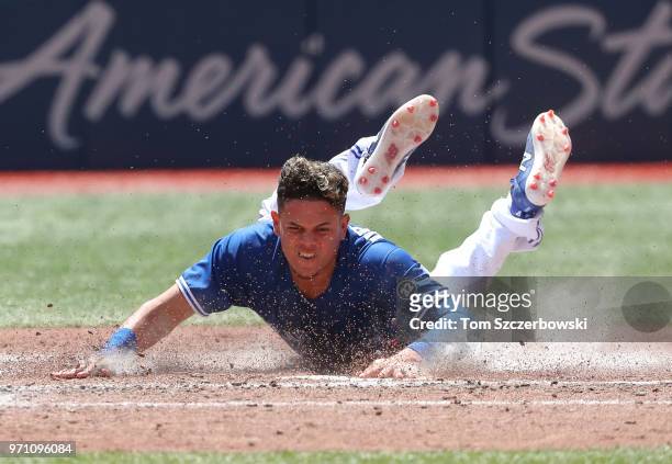 Gio Urshela of the Toronto Blue Jays slides safely across home plate to score a run in the fifth inning during MLB game action against the Baltimore...