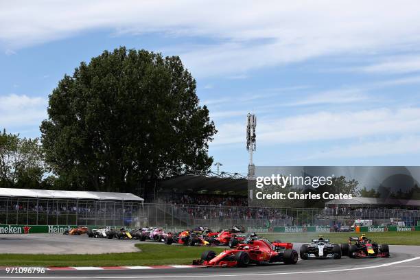 Sebastian Vettel of Germany driving the Scuderia Ferrari SF71H leads the field at the start during the Canadian Formula One Grand Prix at Circuit...