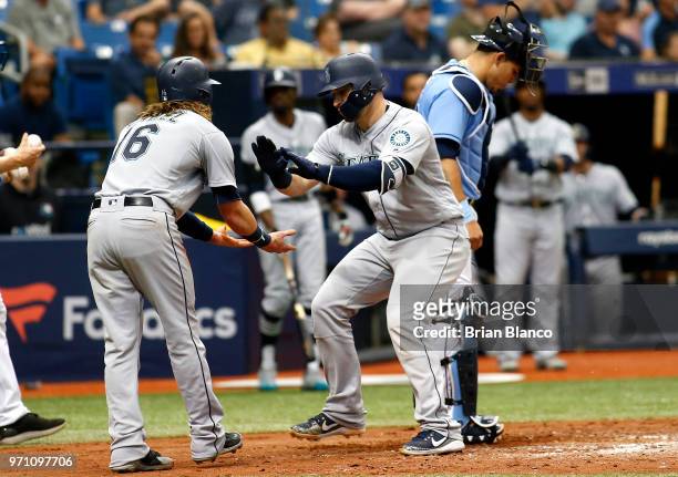 Mike Zunino of the Seattle Mariners celebrates with teammate Ben Gamel in front of catcher Wilson Ramos of the Tampa Bay Rays after scoring off of...