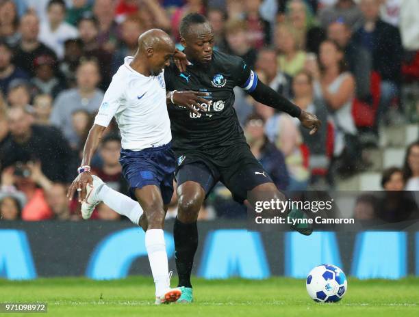 Usain Bolt of the Rest of the World and Sir Mo Farah of England battle for the ball during the Soccer Aid for UNICEF 2018 match between England and...