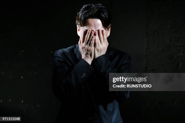 middle aged businessman covering face with hands - obscured face ストックフォトと画像