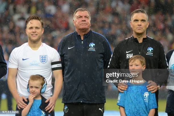 Olly Murs, Sam Allardyce and Robbie Williams line-up prior to kick off during Soccer Aid for Unicef 2018 at Old Trafford on June 10, 2018 in...