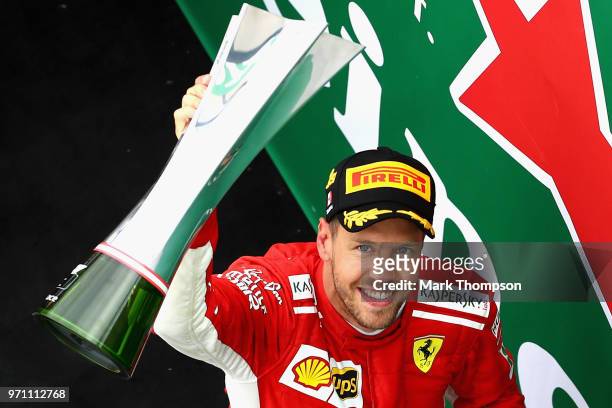 Race winner Sebastian Vettel of Germany and Ferrari celebrates on the podium with his trophy during the Canadian Formula One Grand Prix at Circuit...