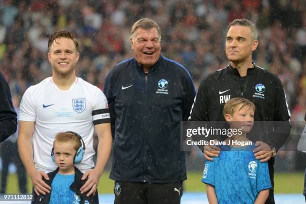 Olly Murs, Sam Allardyce and Robbie Williams line-up prior to kick off during Soccer Aid for Unicef 2018 at Old Trafford on June 10, 2018 in...
