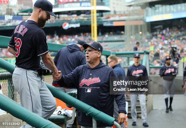 Corey Kluber of the Cleveland Indians walks to the dugout and is congratulated by manager Terry Francona during the end of the eight inning of the...