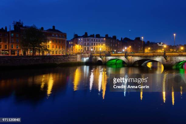 city lights of downtown dublin, ireland, reflected in river liffey at dusk - anna gorin stock-fotos und bilder