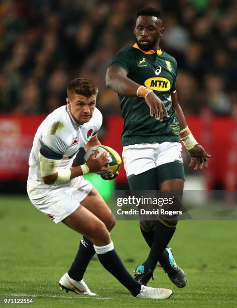 Henry Slade of England moves away from Siya Kolisi during the first test match between South Africa and England at Elllis Park on June 9, 2018 in...