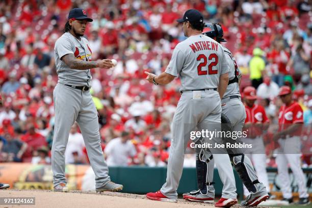 Carlos Martinez of the St. Louis Cardinals hands the ball to manager Mike Matheny after being replaced in the fourth inning against the Cincinnati...