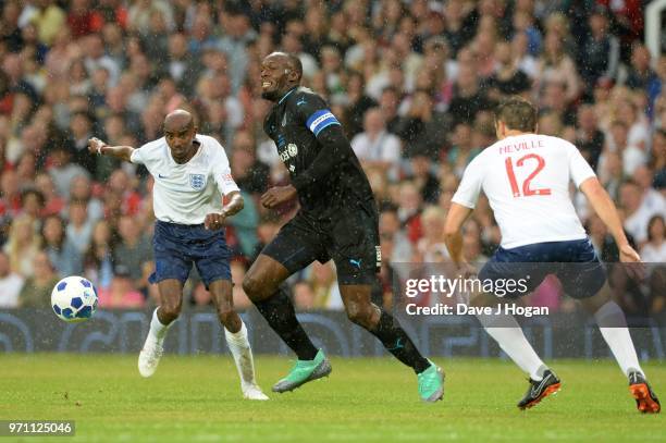 LMANCHESTER, ENGLAND Usain Bolt in action against Wes Brown and Phil Neville and Sir Mo Farah during Soccer Aid for Unicef 2018 at Old Trafford on...