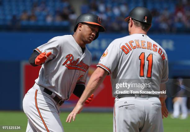 Jonathan Schoop of the Baltimore Orioles is congratulated by third base coach Bobby Dickerson after hitting a solo home run in the seventh inning...